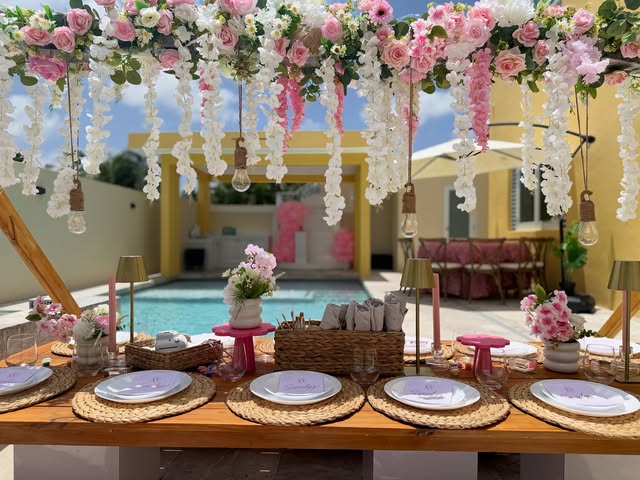 Mesa de picnic bajo techo de flores junto a la piscina